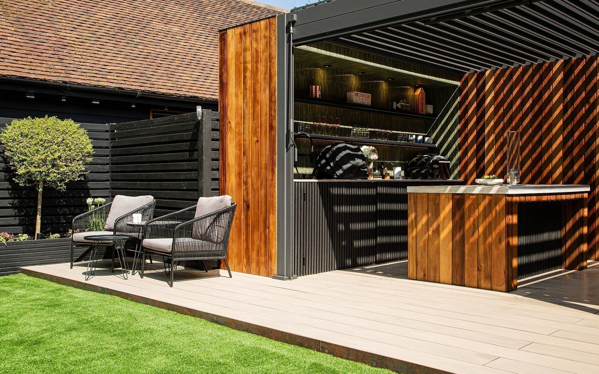 Ash White composite decking surrounding a hot tub with Charcoal slatted cladding in a Much Hadham garden