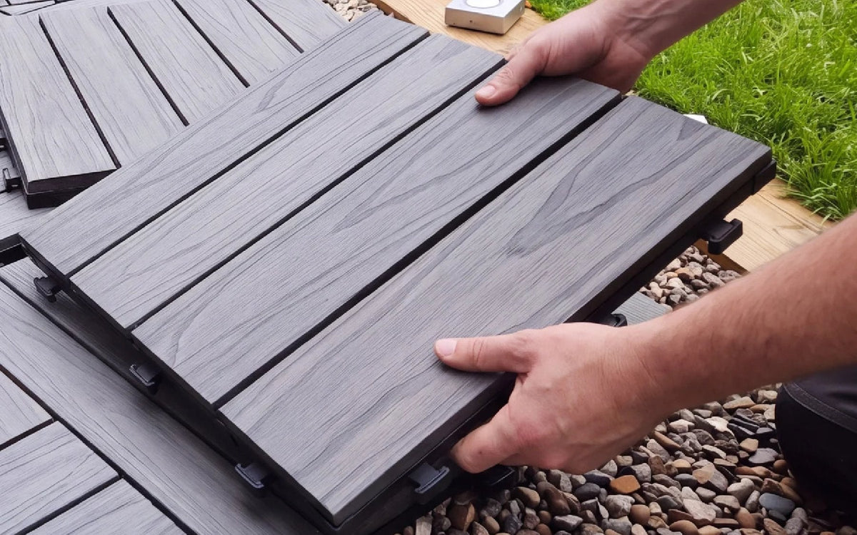 Grey interlocking tiles being installed, illustrating the best composite deck tiles for an outdoor space.