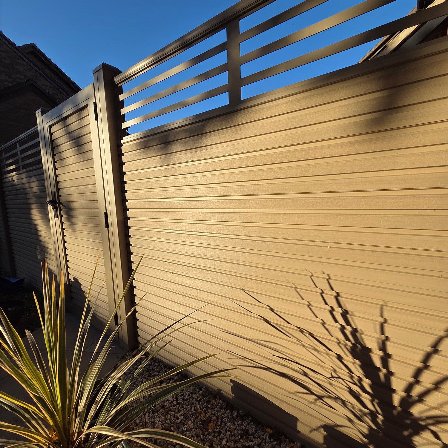 neotimber composite fence with horizontal slats and a clear blue sky