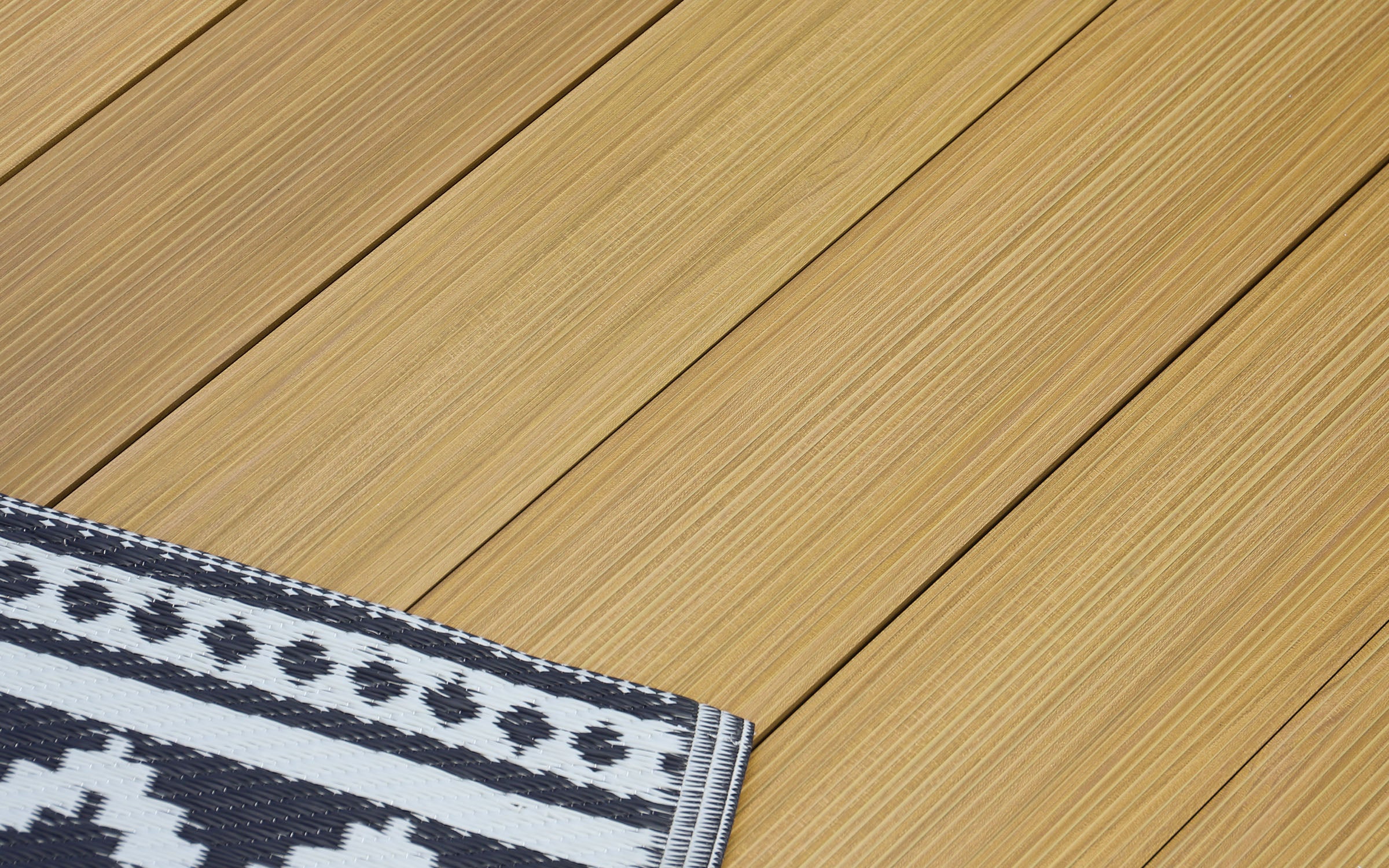 NeoTimber Aluminium Decking Samples - patterned rug on a aluminium deck