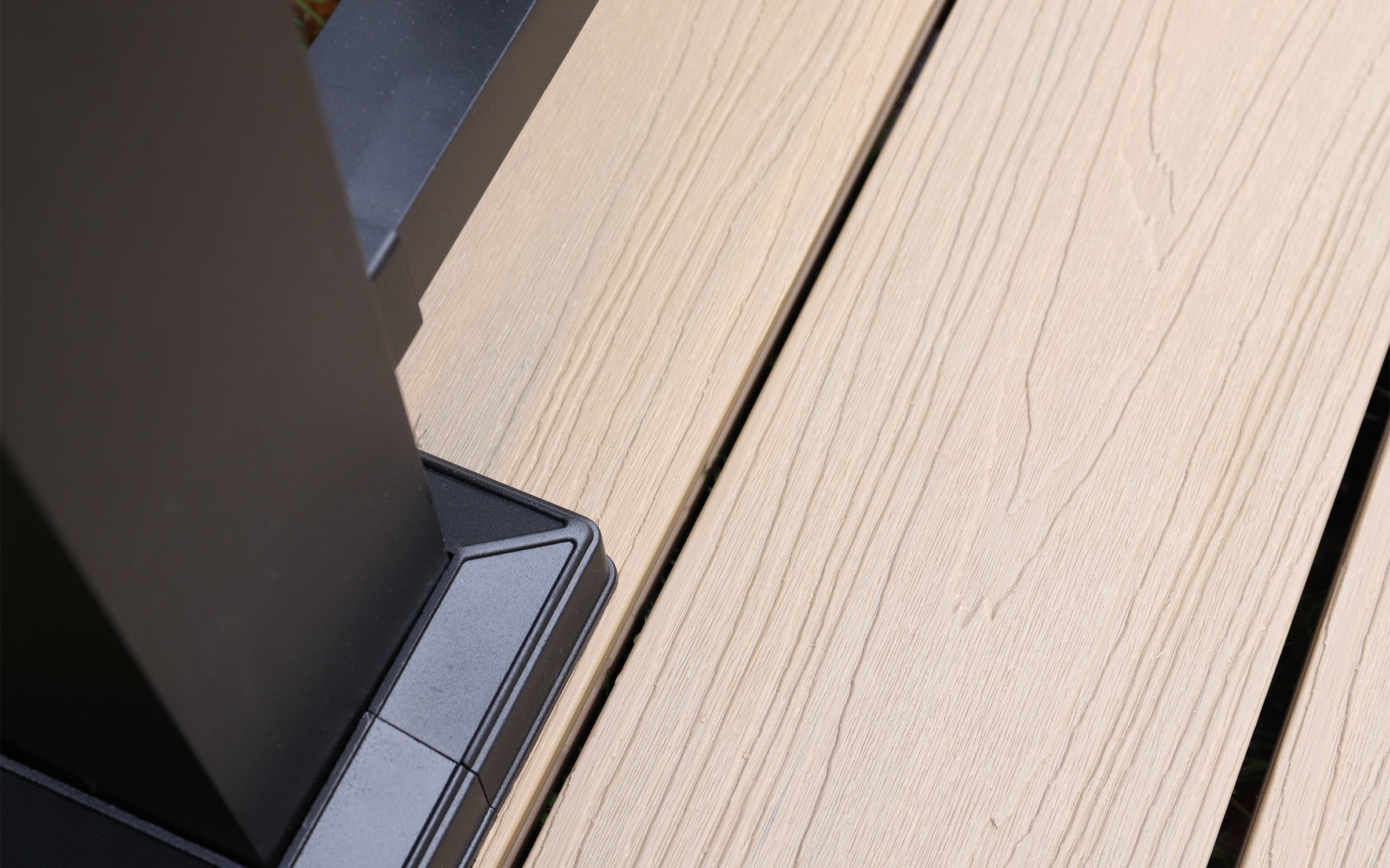 close-up of a black aluminium balustrade post installed on a composite decking surface