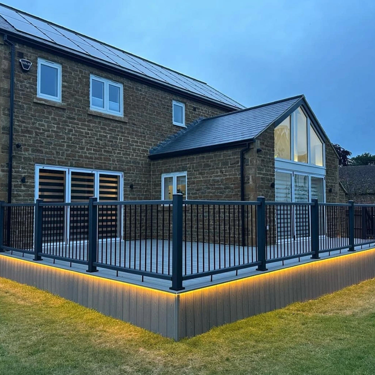 brick house with a modern deck, composite balustrade and lighting