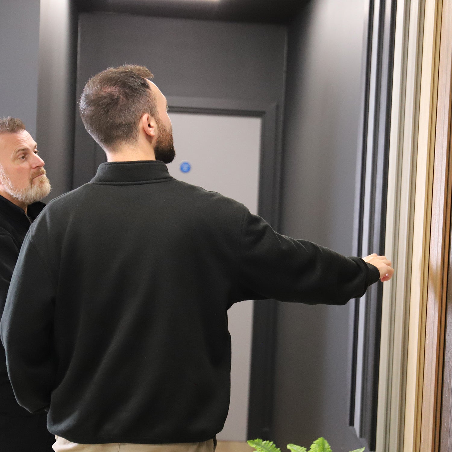 two men inspecting full-length composite decking boards in the neotimber showroom