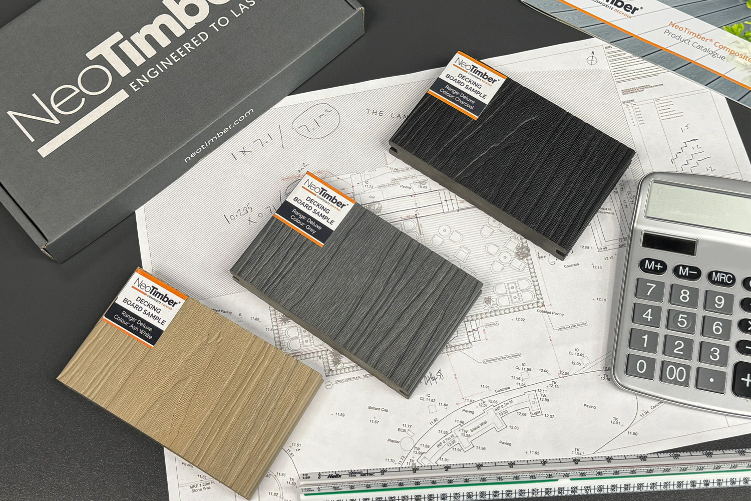 NeoTimber decking samples on a technical drawing with a calculator and branded box