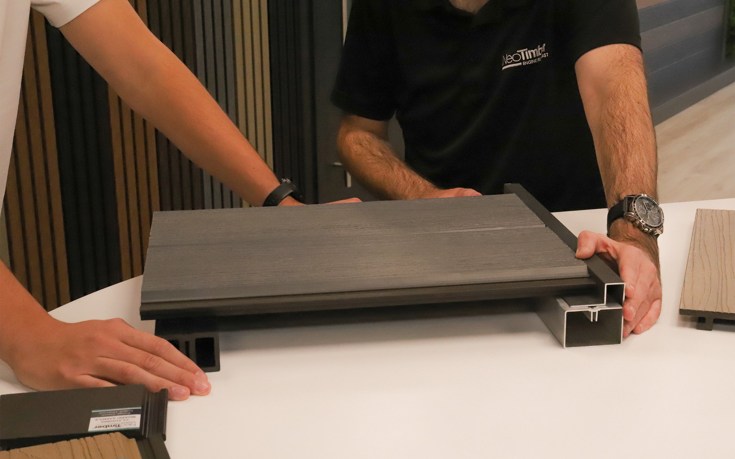 two people examining a decking subframe design on a table