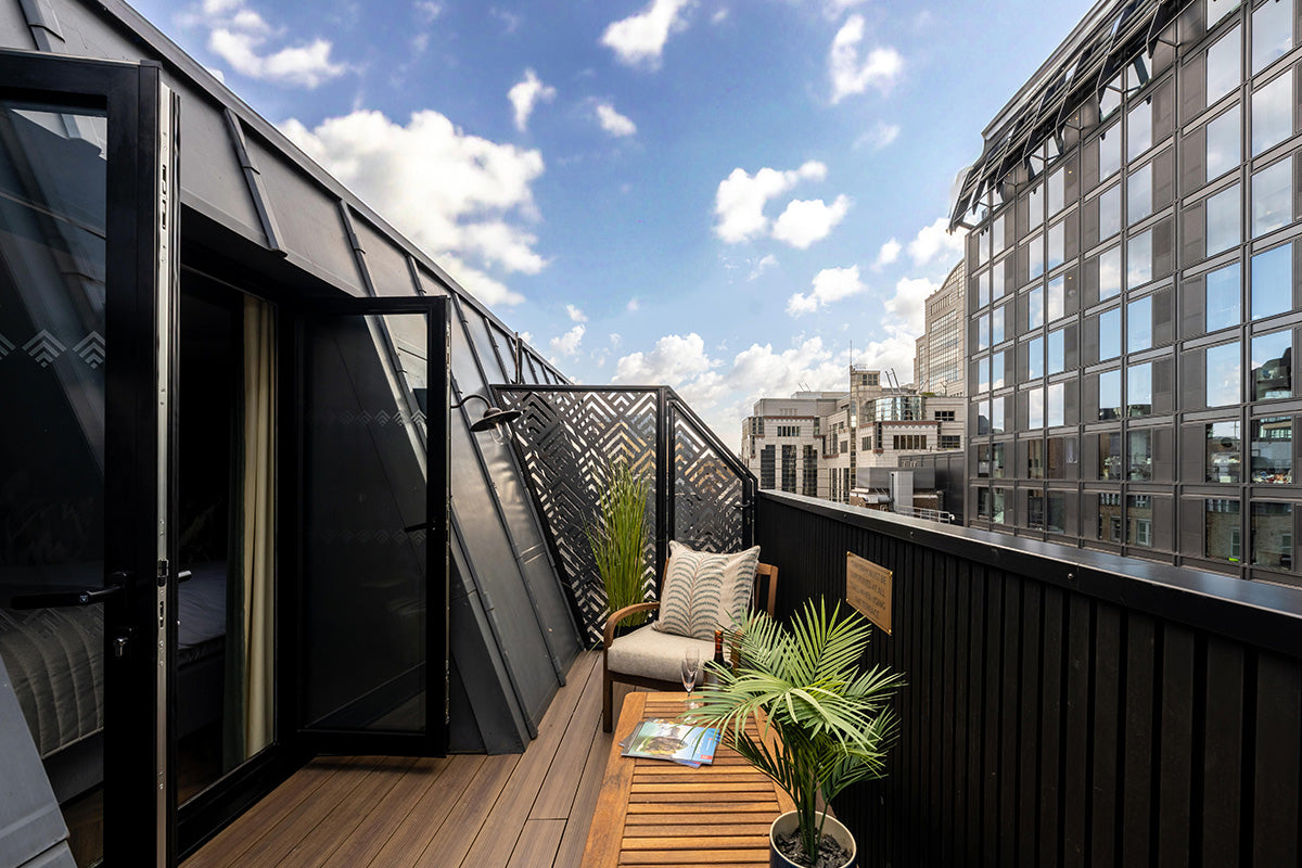 modern rooftop terrace with aluminium wood-effect deck, chairs, and cityscape view