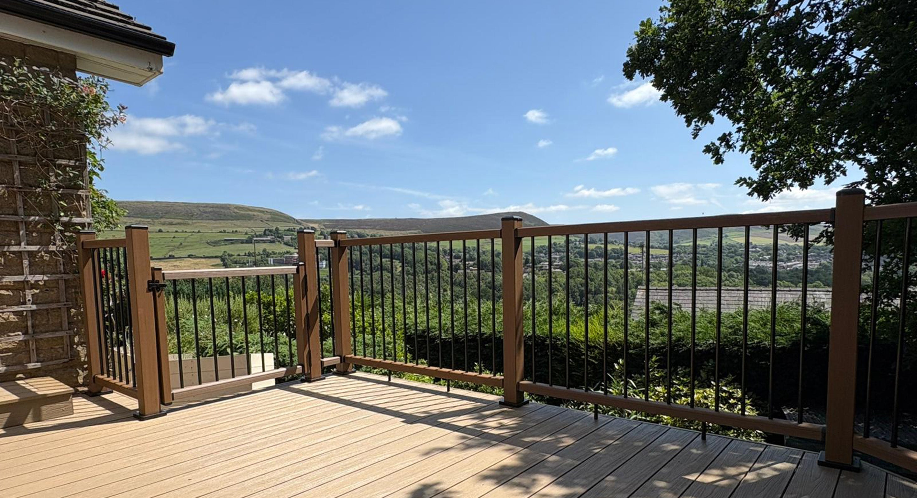 composite deck with railing overlooking a scenic landscape with trees and mountains