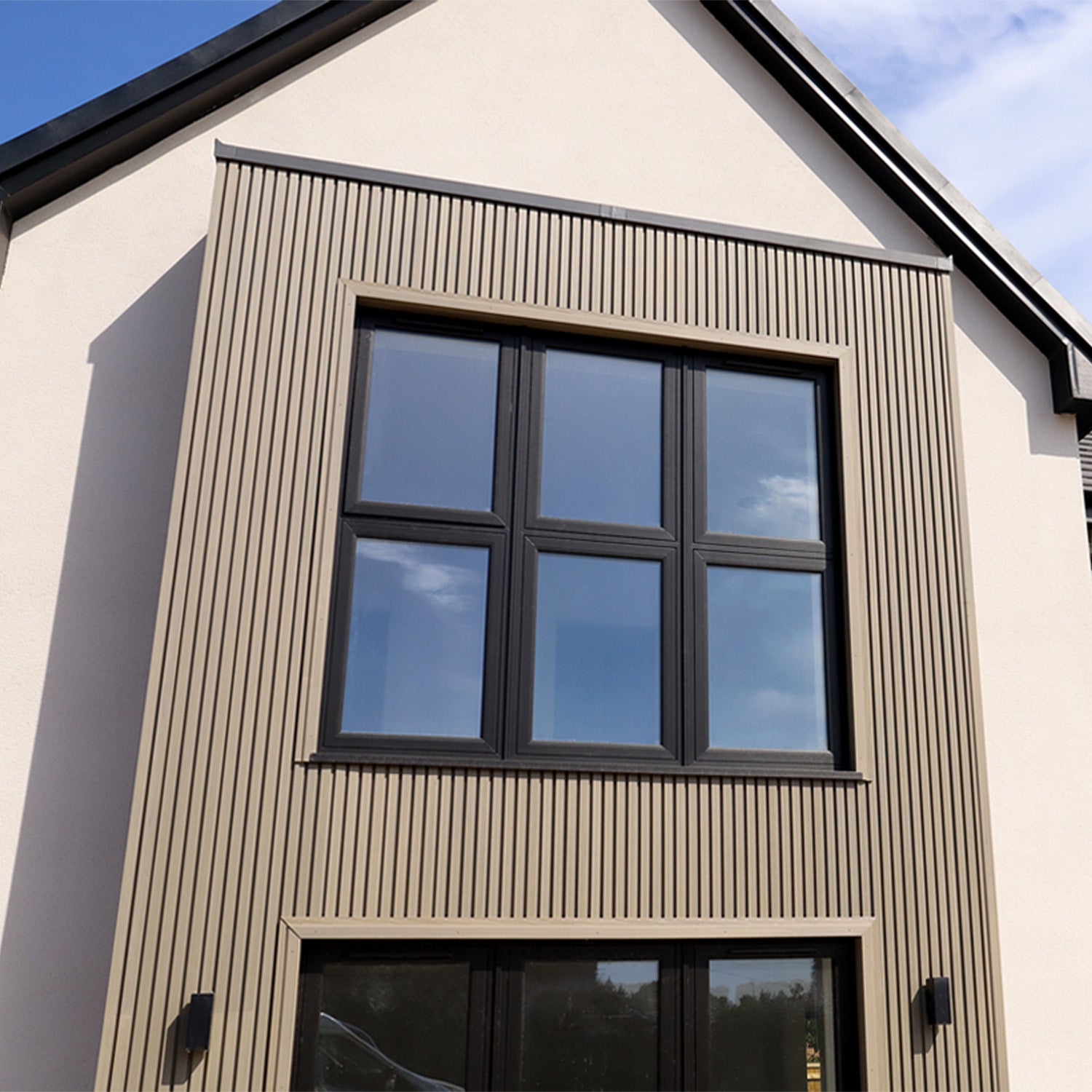 modern house exterior with a large window and composite cladding