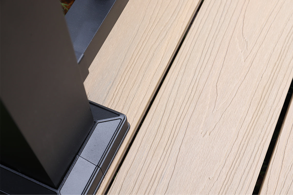 close-up of a composite deck surface with a black aluminium balustrade post visible