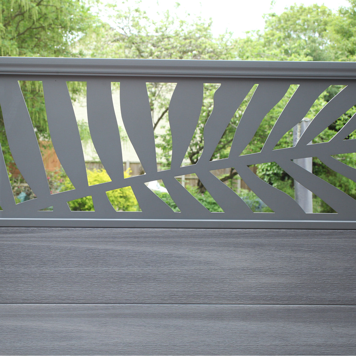 neotimber deluxe grey composite fence panel with decorative screen and greenery in the background