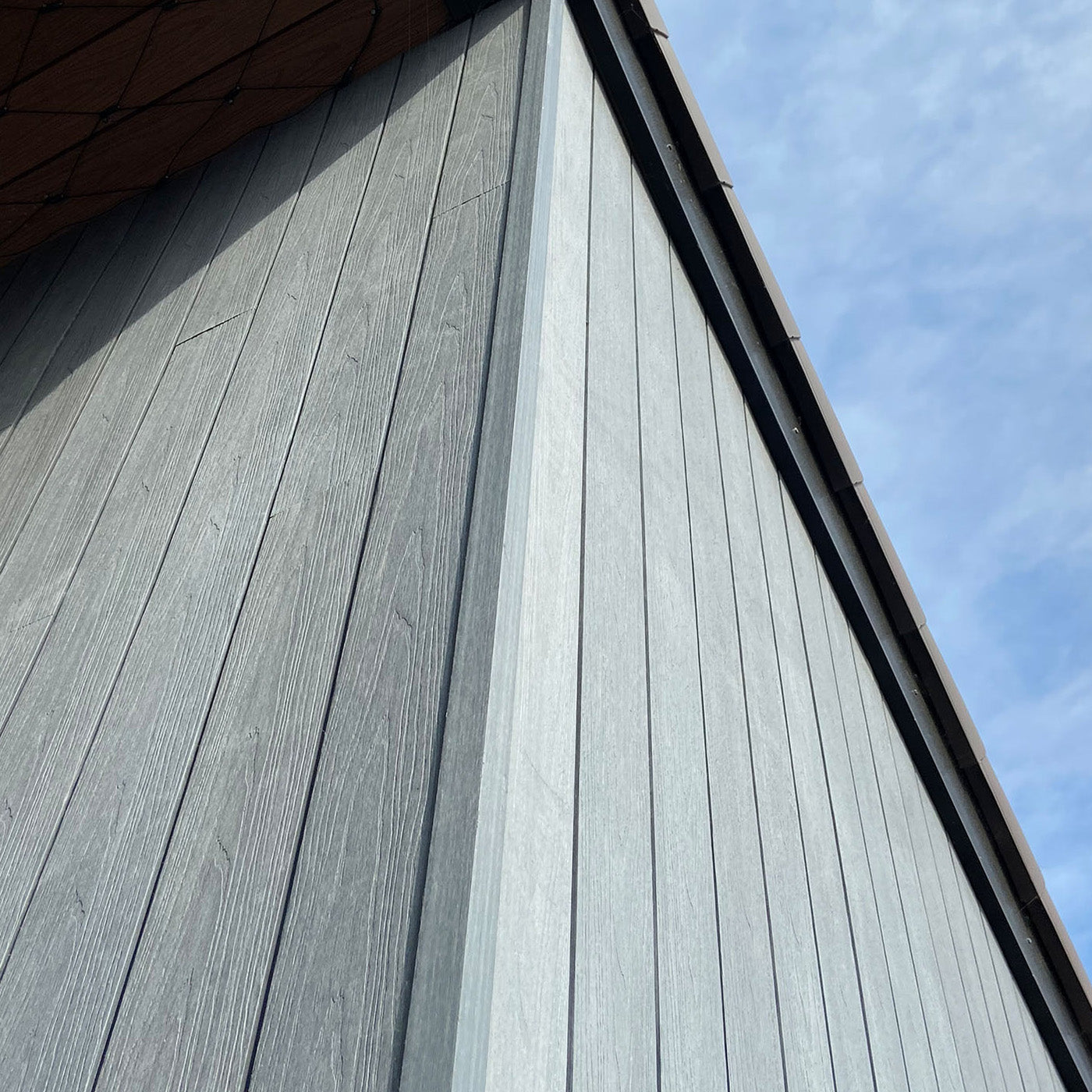 close-up of grey composite cladding facade on a building with clear blue sky