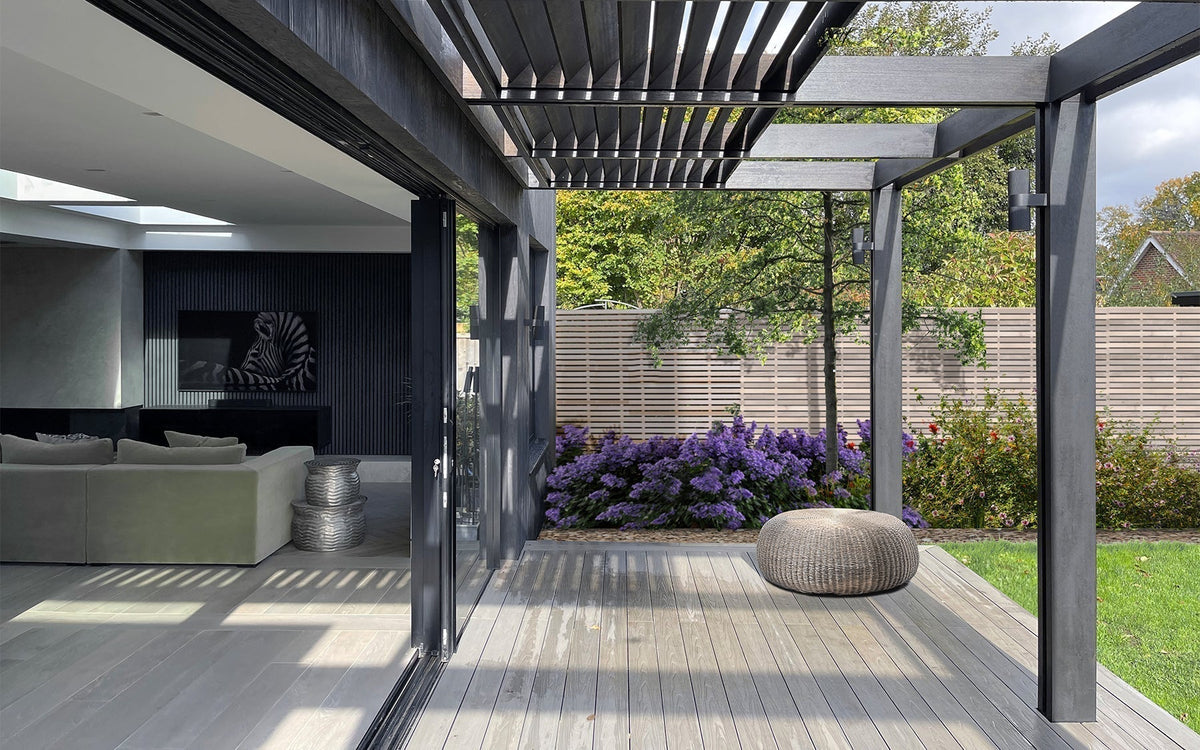 Antique composite decking beneath a timber-louvred pergola beside the Black House extension in Windsor