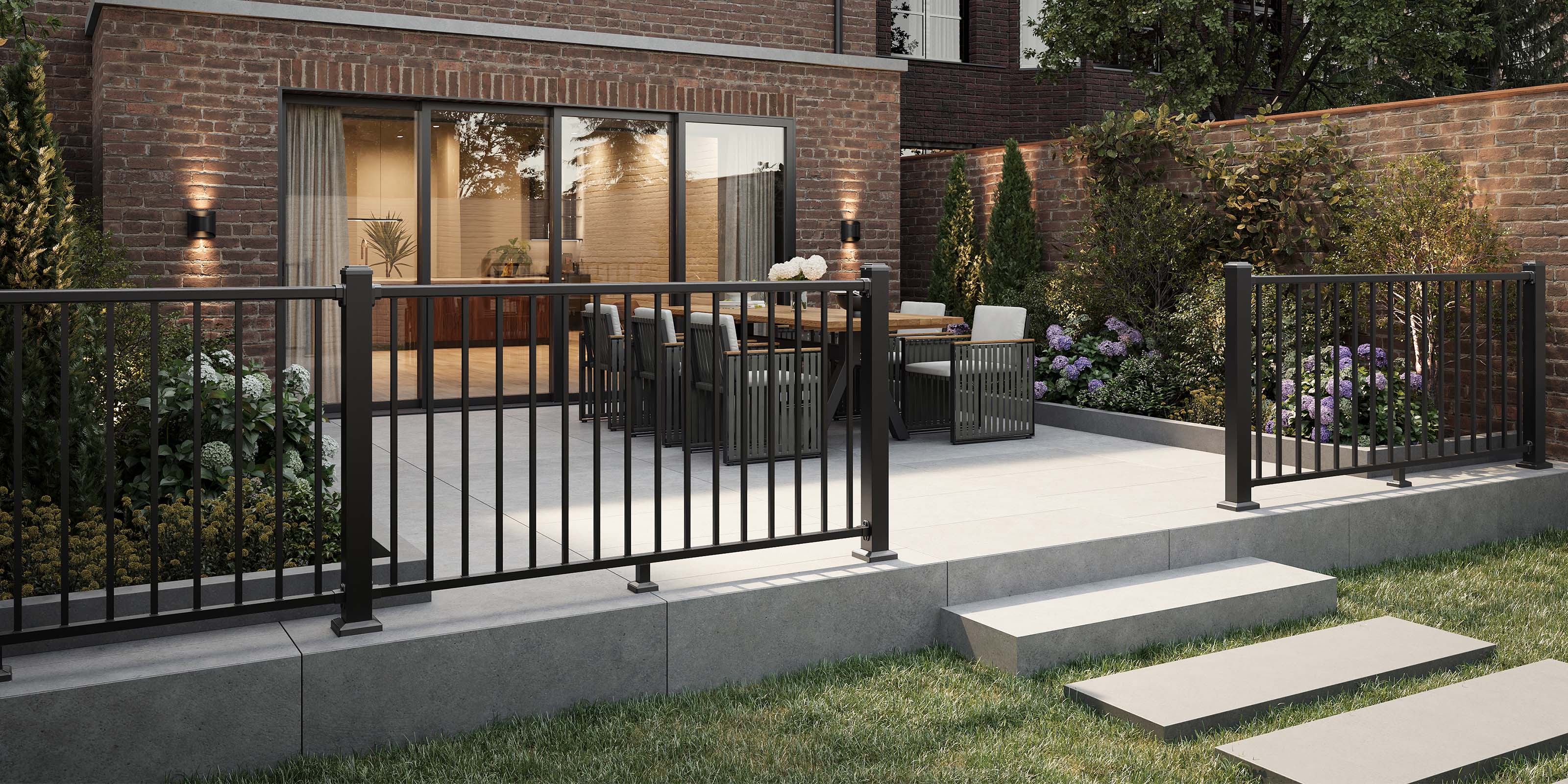 outdoor patio area with neotimber black metal balustrade railing, chairs, and a brick building
