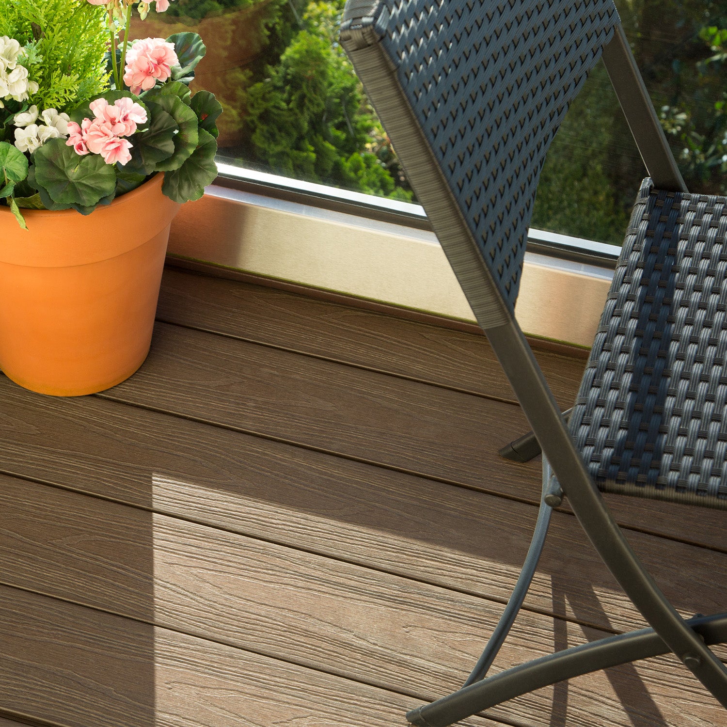 potted plant on a composite balcony deck with a chair in the background