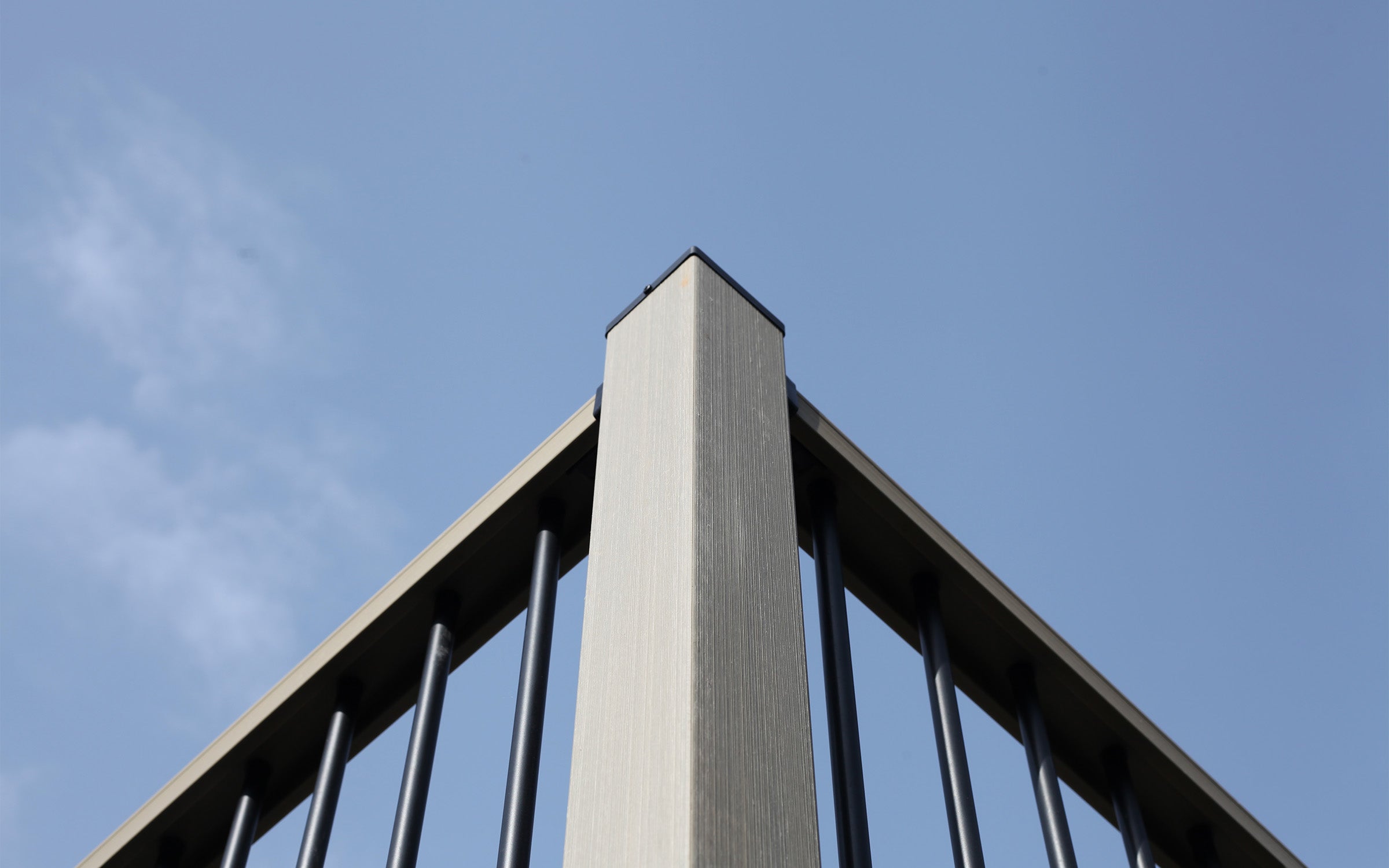 close-up of composite post and railing with a clear blue sky background