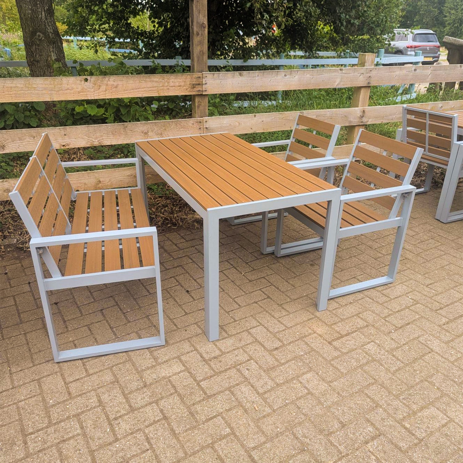 outdoor composite furniture set with table and chairs on a paved patio