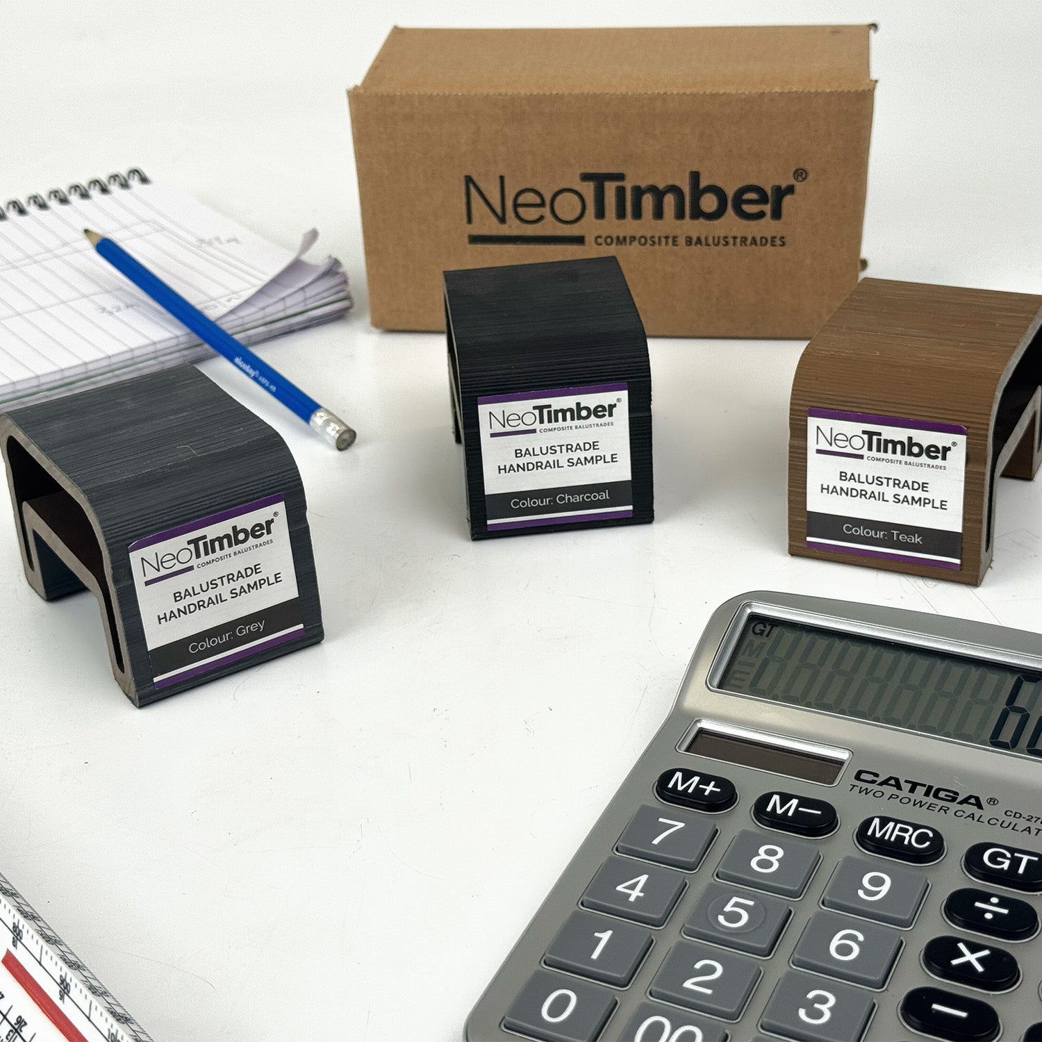 NeoTimber composite balustrade samples with a calculator on a white table