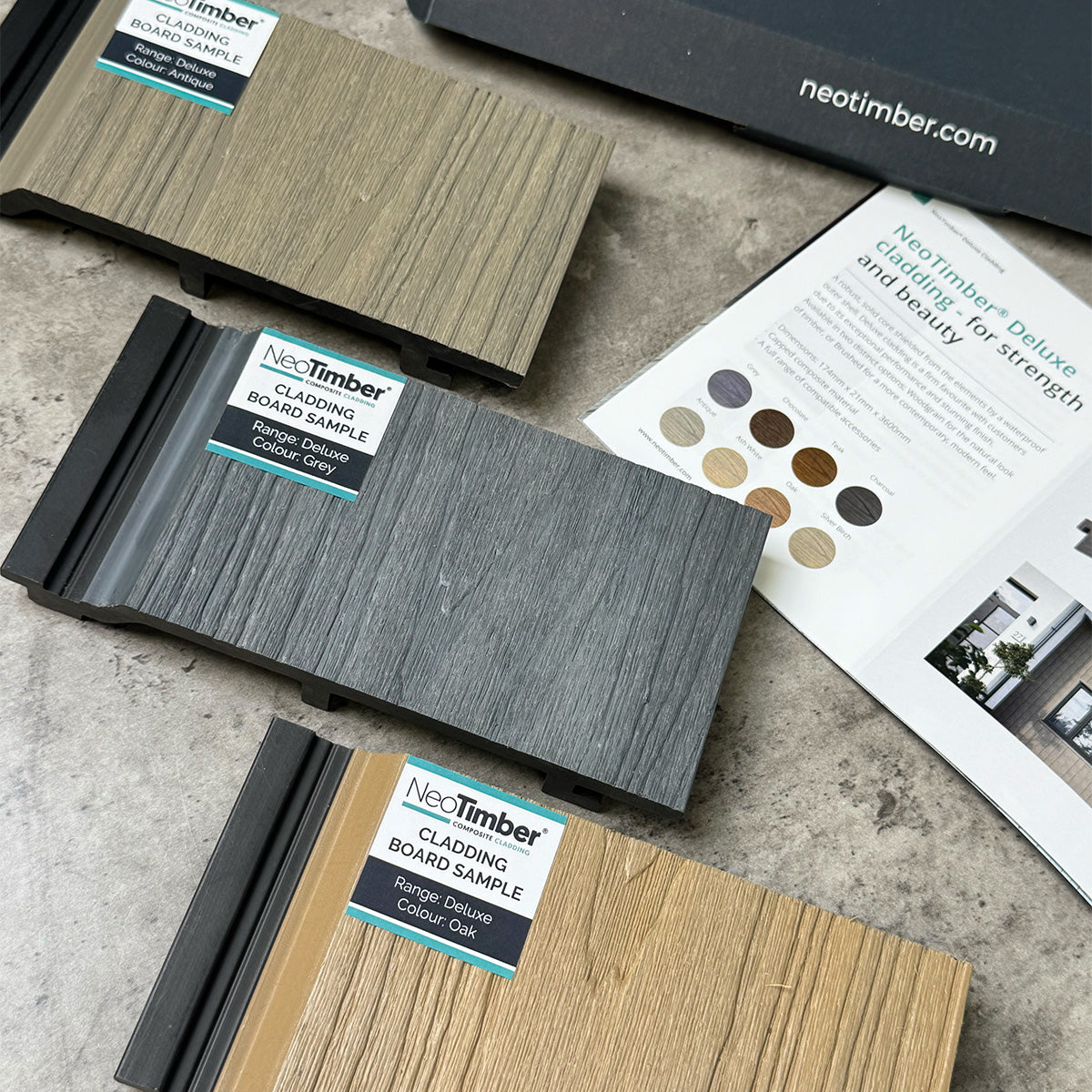 neotimber cladding board samples on a concrete surface with a colour swatch book