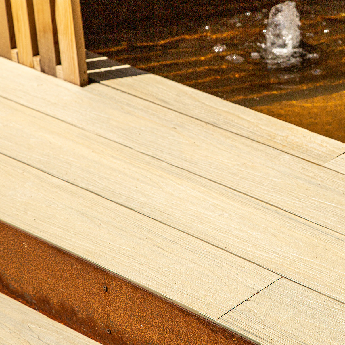 neotimber composite deck with a water feature in the background