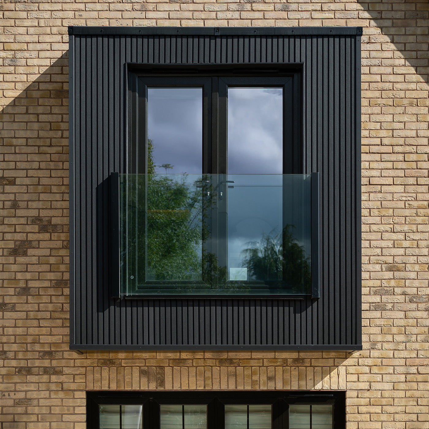 window with black composite cladding frame on a brick wall