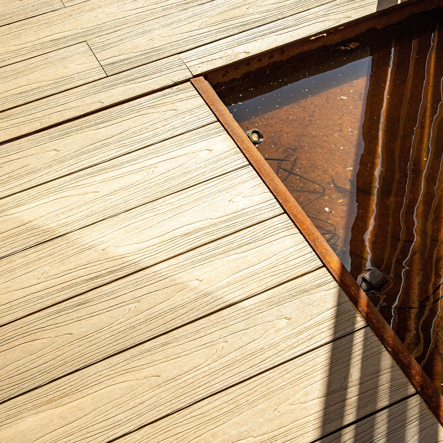 composite deck with a metal grate partially submerged in water
