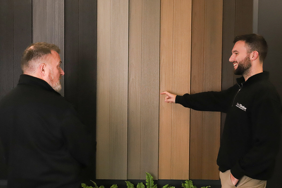 two men discussing a wall of composite cladding paneling