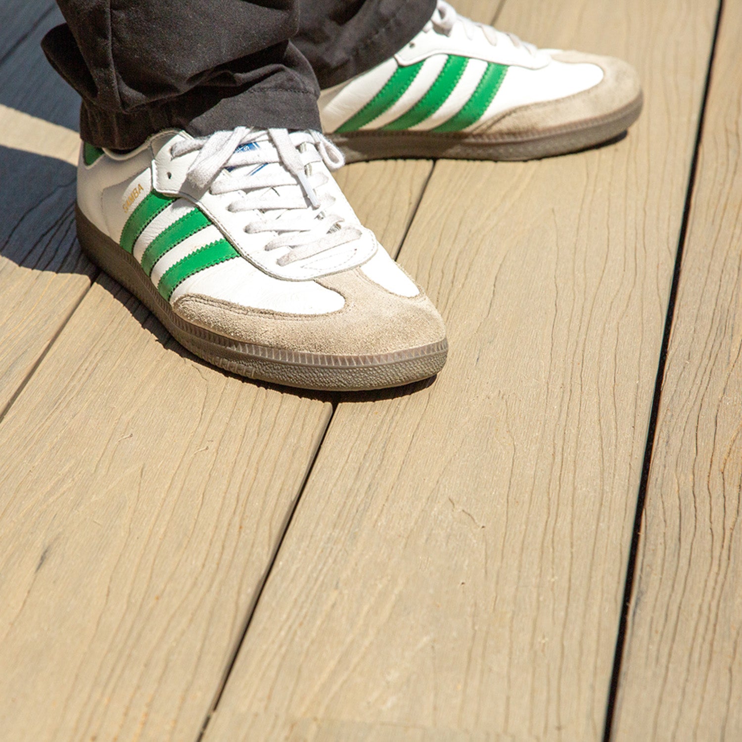 white sneakers with green stripes on a neotimber composite deck floor