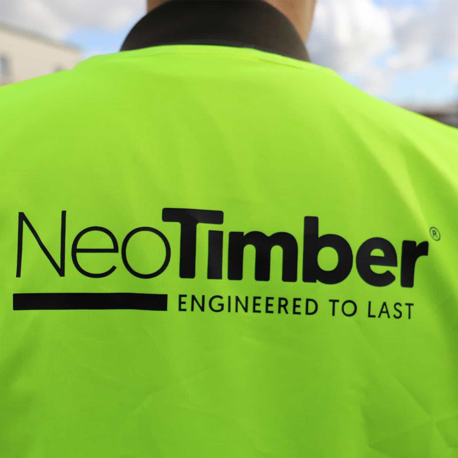 person wearing a high-visibility jacket with NeoTimber® branding on the back