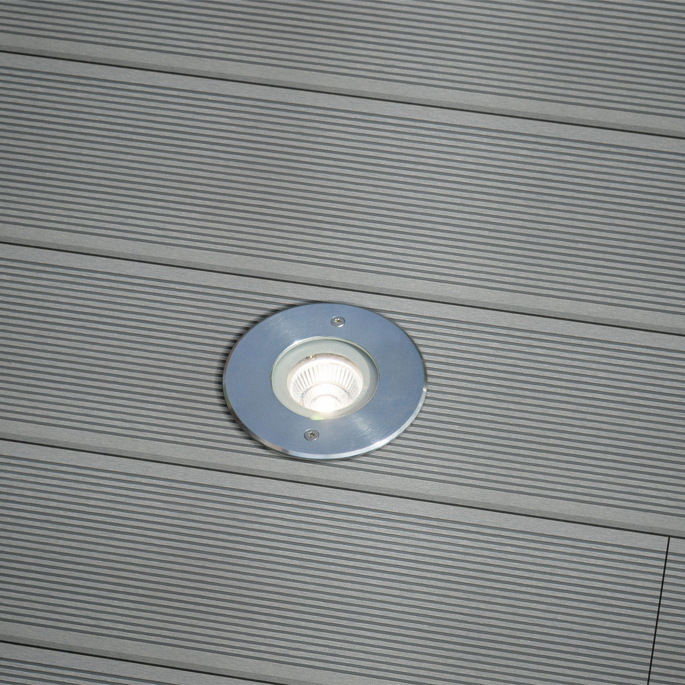 round recessed light fixture on a groove-textured composite deck
