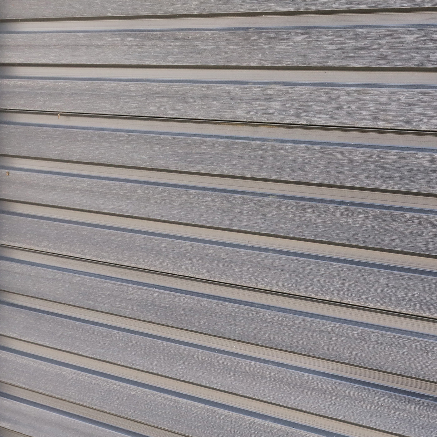close-up of horizontal composite cladding boards with a grey-brown wood-effect finish
