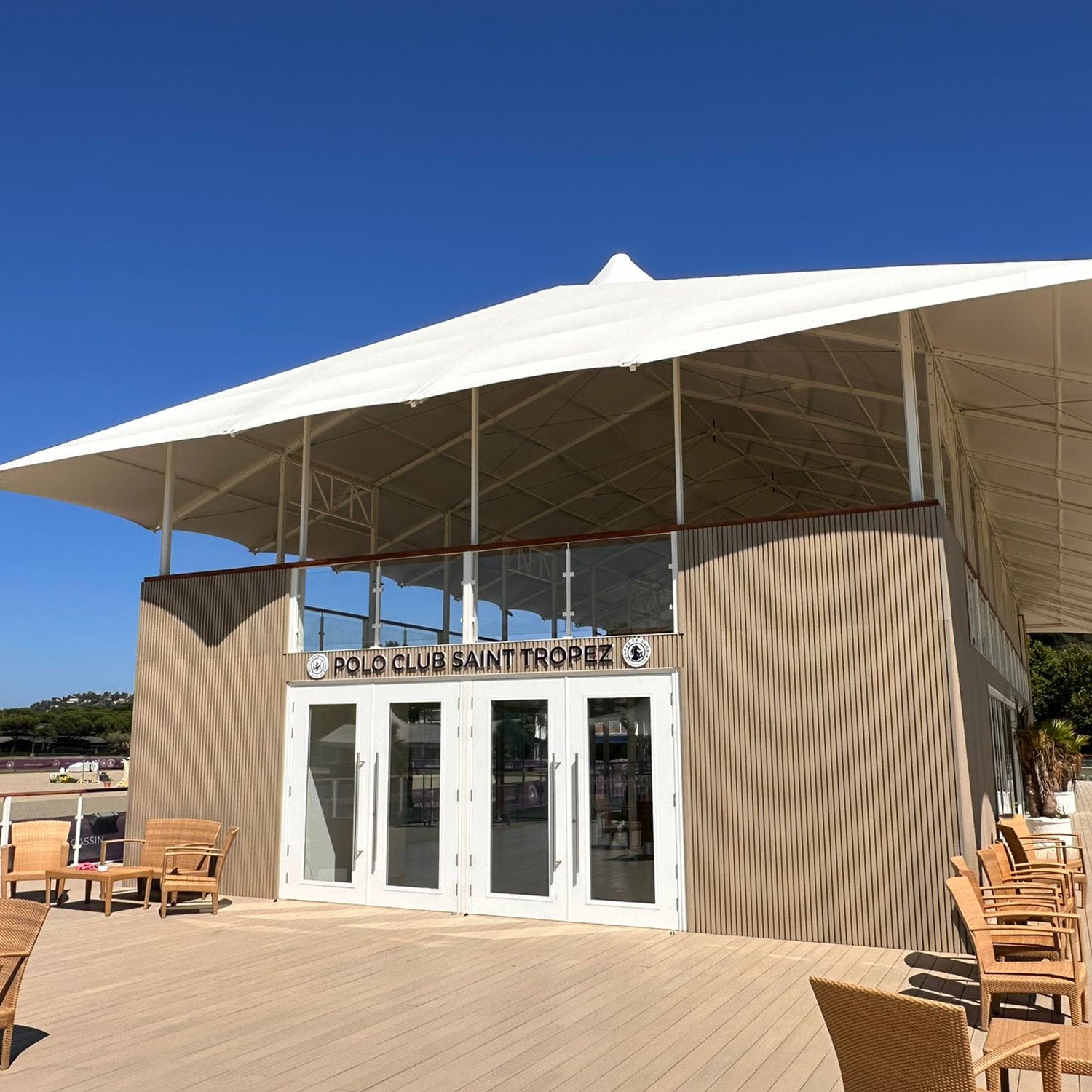 Polo Club Saint-Tropez building featuring NeoTimber® composite cladding and decking with an outdoor seating area on a clear day