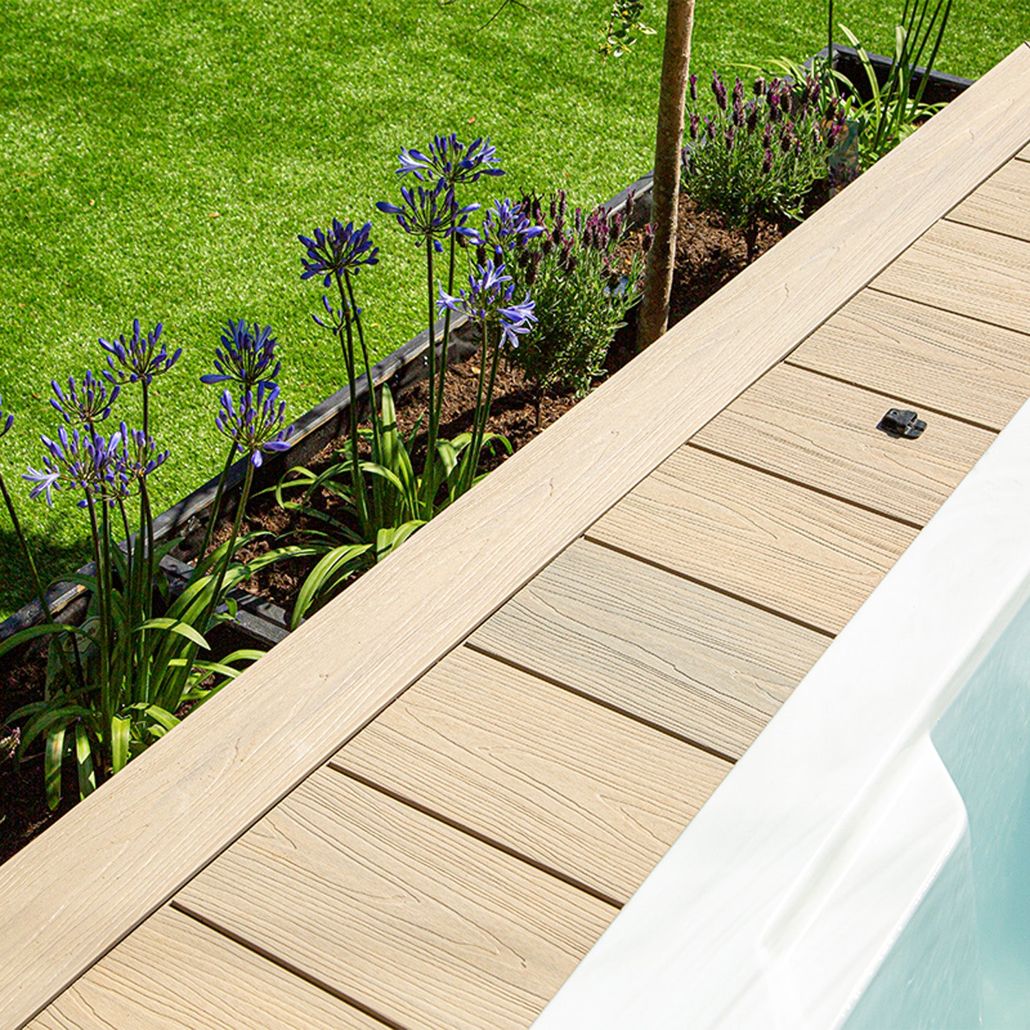 slip-resistant composite decking surrounded by a landscaped garden with purple flowers and lush green lawn
