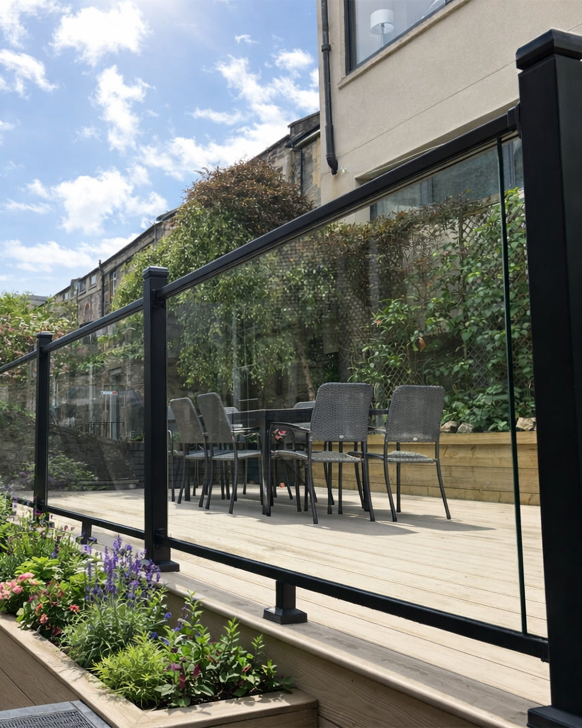 neotimber glass railings on a composite deck with outdoor furniture and garden plants