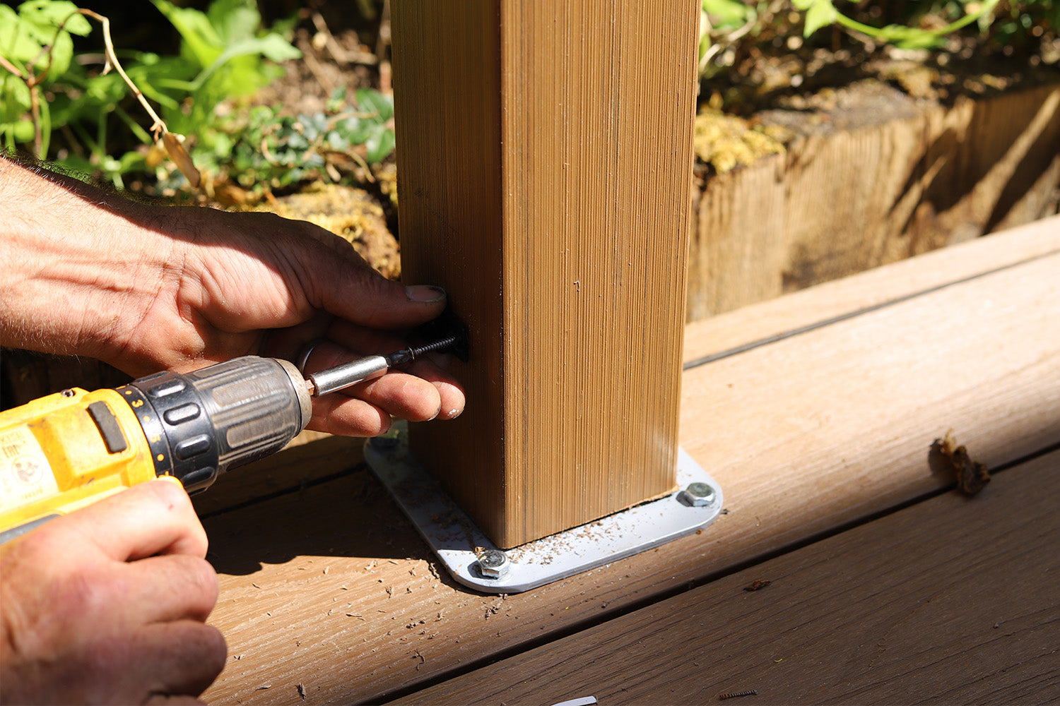 person using a drill to secure neotimber composite balustrade post