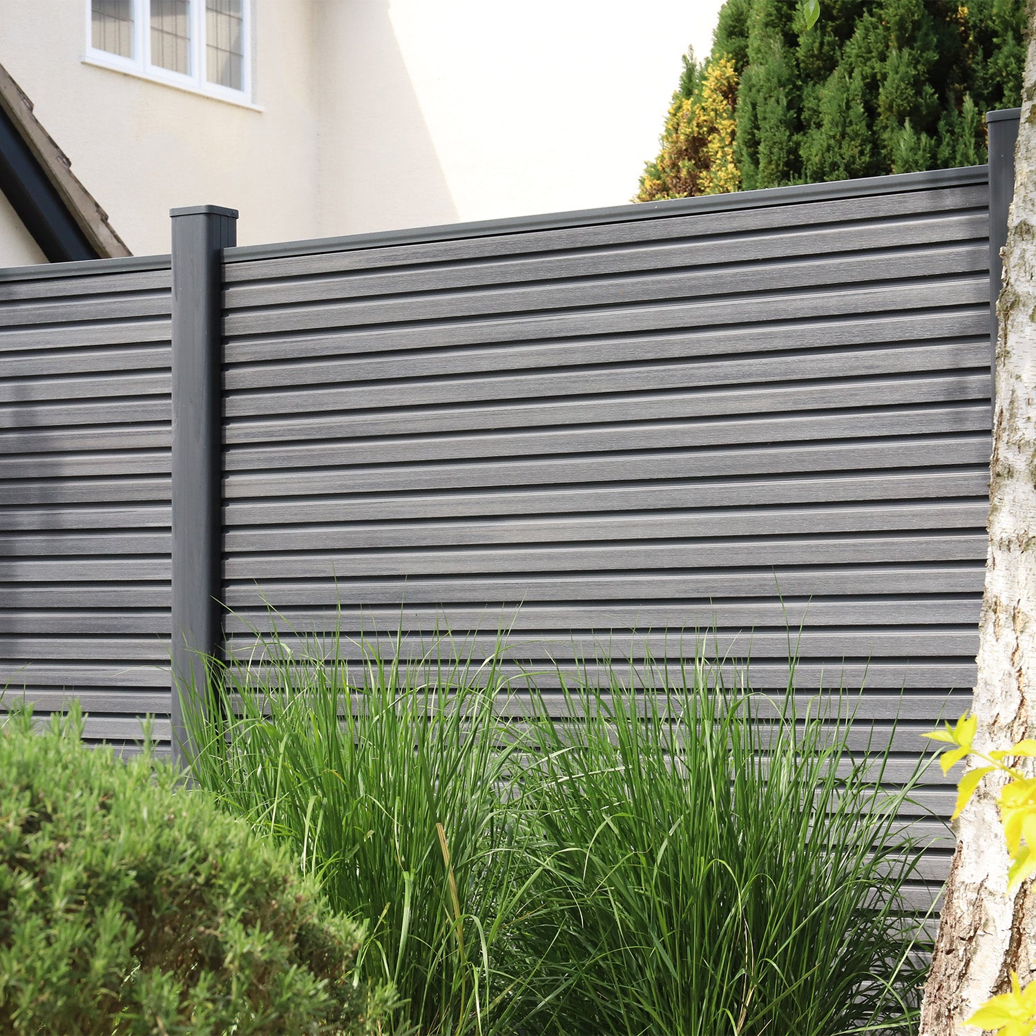 neotimber grey slatted fence with greenery in front of a house