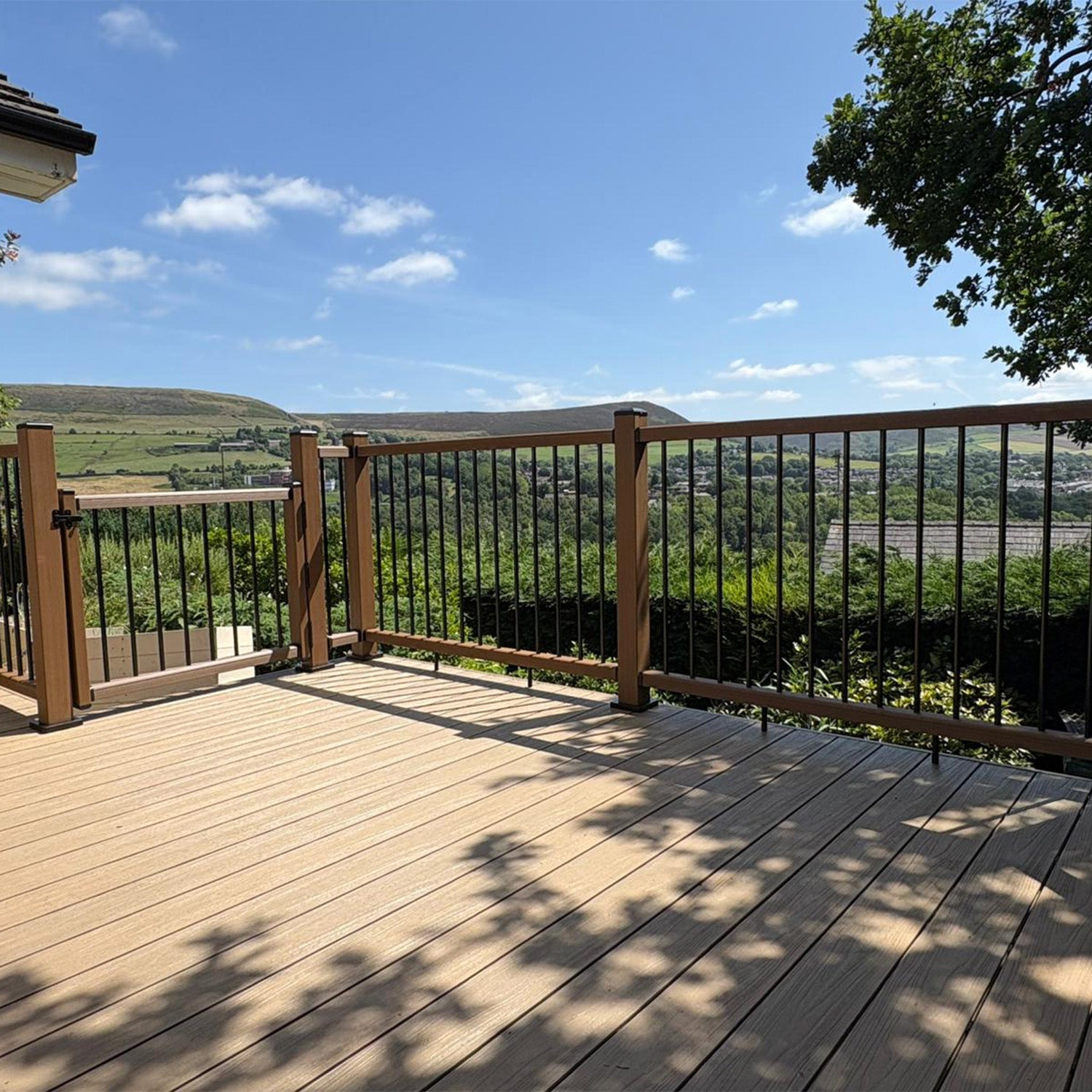 composite deck with railing overlooking a scenic landscape with trees and hills
