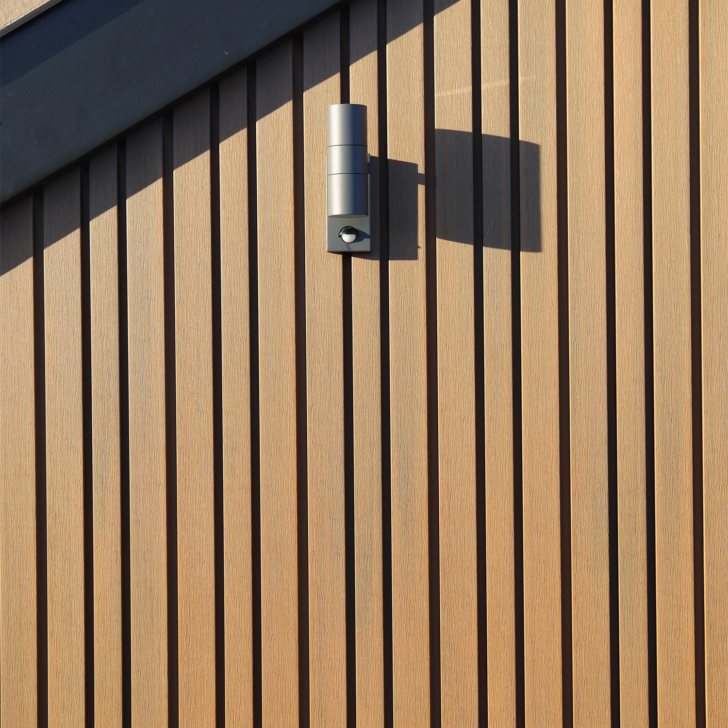NeoTimber Slatted Composite Cladding Wall With Contemporary Cylindrical Light Fixture