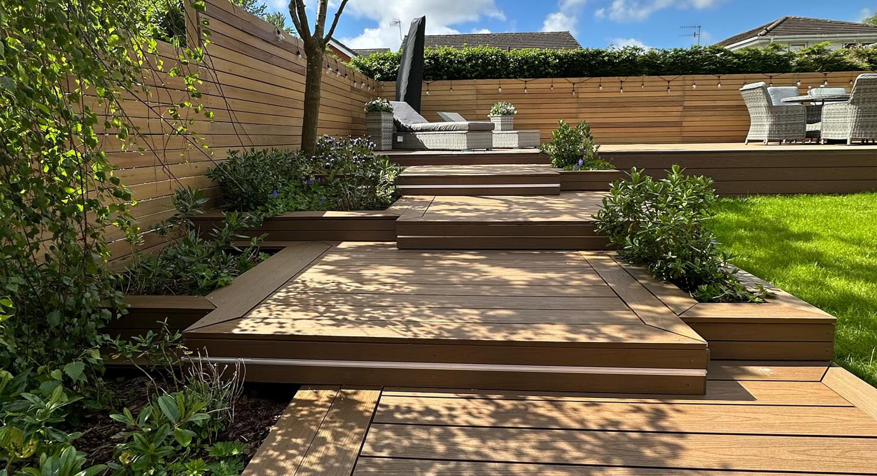 composite deck with steps leading to a patio area with outdoor furniture