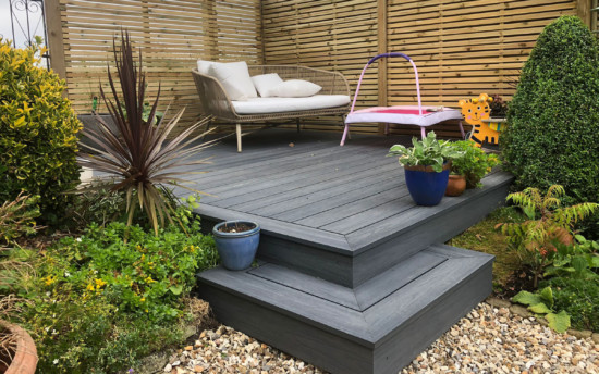 composite decking in corner of garden with furniture