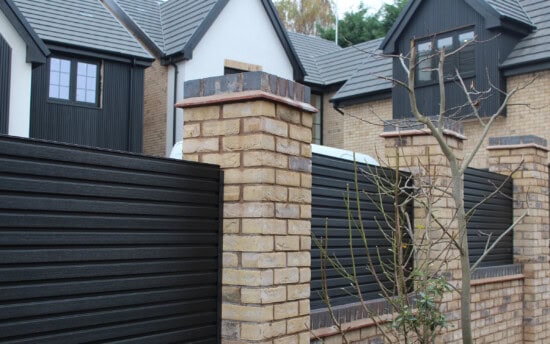charcoal composite fencing paired with brick wall